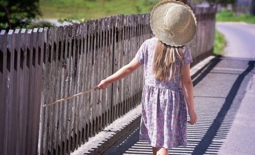 child by natural board fence